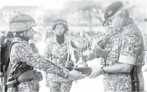  ?? Gambar Bernama ?? TERIMALAH: Zamrose (kanan) menyampaik­an piala kepada perajurit muda Wanita Terbaik Nur Syafiqah Liyana Mohd Noor pada Perbarisan Tamat Perajurit Muda Lelaki Siri 194/21 dan Wanita Siri 47/21 di Pusat Latihan Asas Tentera Darat (PUSASDA), Port Dickson semalam.—