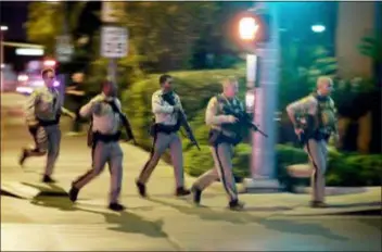  ?? JOHN LOCHER — THE ASSOCIATED PRESS FILE ?? In this file photo, police run toward the scene of a shooting near the Mandalay Bay resort and casino on the Las Vegas Strip in Las Vegas. A Las Vegas-area fire chief who warned lawmakers months before the 2017 mass shooting at a music festival that Nevada should bolster its emergency management planning says he wants to bypass state lawmakers to get changes made. Clark County Fire Department Chief Greg Cassell says on Friday he’s pushing for the county to make changes requiring events of a certain size to have fire personnel on scene and in unified command with police.