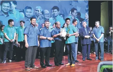  ??  ?? Uggah (third left) presents the Best Sportsman Award to Loh Jack Chang. Also seen (from left) are Tourism, Arts, Culture,Youth and Sports Ministry permanent secretary Datu Ik Pahon Joyik, Assistant Minister of Youth and Sports Snowdan Lawan, Karim,...