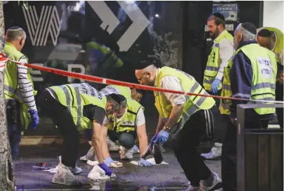  ?? (Noam Revkin Fenton/Flash90) ?? POLICE AND rescue personnel work at the scene of last month’s terror attack in Tel Aviv in which three people were killed. The terror wave has been dominated by assailants who decided on their own to launch indiscrimi­nate attacks.