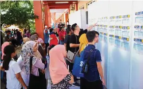  ??  ?? On the board: Visitors looking at the list of companies present at the recent SL1M roadshow in Sepanggar, Sabah.