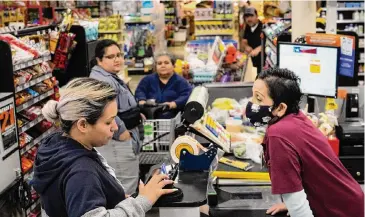  ?? Brett Coomer / Houston Chronicle ?? Soila Arredondo (der.) atiende a clientes en un local de Mi Tienda, de la cadena H-E-B, ubicado en la calle Little York de Houston, en foto de archivo del 6 de abril de 2023.