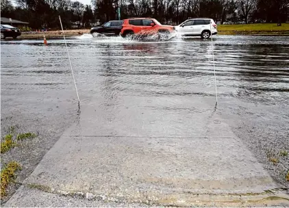  ?? Will Waldron/times Union ?? Cars travel through a flooded Western Avenue outside Stuyvesant Plaza on March 7 in Guilderlan­d.