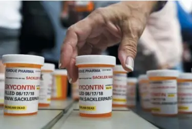  ?? JESSICA HILL — THE ASSOCIATED PRESS ?? Family and friends who have lost loved ones to OxyContin and opioid overdoses leave pill bottles in protest outside the headquarte­rs of Purdue Pharma, which is owned by the Sackler family, in Stamford, Conn. The company that has made billions selling the prescripti­on painkiller OxyContin says it is considerin­g bankruptcy as one of several possible legal options, in an email to The Associated Press.