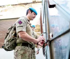  ?? ?? Members of the United Nations Peacekeepi­ng Force in Cyprus check a lock while patrolling along the buffer zone.