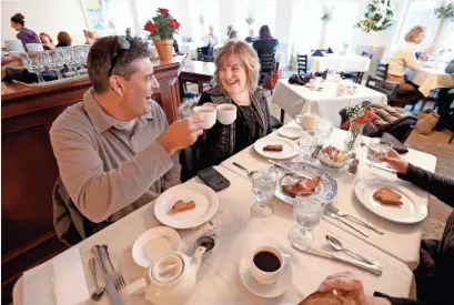  ?? MIKE DE SISTI / MILWAUKEE JOURNAL SENTINEL ?? George Menos of Wauwatosa and his sister Michelle DiCristo of Buffalo Grove, Ill., offer cheers with cups of tea last week while celebratin­g a birthday at the Watts Tea Shop, which is shutting down Saturday. For a video and more photos, go to...