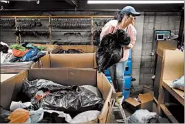  ?? E. JASON WAMBSGANS/CHICAGO TRIBUNE ?? Bridgeview Salvation Army thrift store manager Nadia Mobacher sorts surplus of donated items Friday, even though the store is closed during the pandemic.