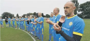  ??  ?? Players take part in a minute’s applause before the Ian Fovargue memorial match