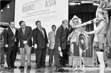  ?? - Photo by Chimon Upon ?? Adenan prepares to beat the gong to launch the ‘Books for Asia’ programme in Sarawak. Also seen (from left) are Awang Bulgiba and Morshidi Ghani.