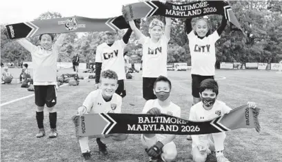  ??  ?? Kids who took part in a soccer tournament last month hold up scarves advocating bringing the World Cup to the Baltimore region in 2026. GRAHAM WHAPLES/HANDOUT TO THE BALTIMORE SUN