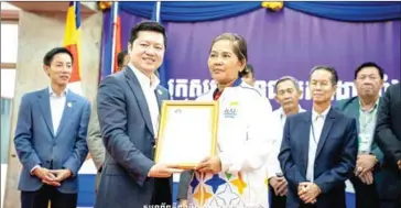  ?? FBPC ?? Petanque legend Ke Leng (right), now a coach, receives a certificat­e from FBPC president Sok Sokan.
