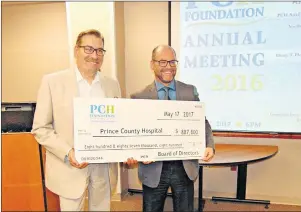  ?? DESIREE ANSTEY/ JOURNAL PIONEER ?? Dr. Scott Cameron, left, of Prince County Hospital, is handed a cheque for $887,800 by emcee Patrick Sweeny of the Prince County Hospital Foundation to put towards new medical equipment.
