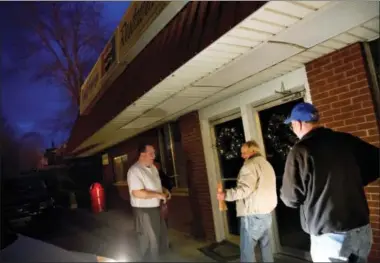  ?? DAVID GOLDMAN — THE ASSOCIATED PRESS ?? Steven Whitt, left, opens the Frosty Freeze restaurant he runs with his wife as regular customers wait outside in Sandy Hook, Ky., Thursday. The regulars amble in before dawn and claim their usual table, the one next to an old television set playing...