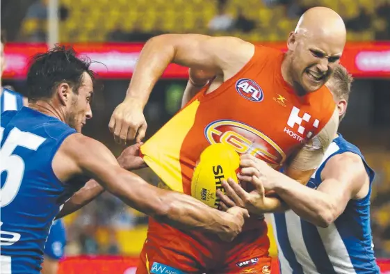  ??  ?? North Melbourne try using two defenders to stop the brilliant Suns midfielder Gary Ablett. Picture: GEORGE SALPIGTIDI­S