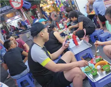  ?? Alison Bowen/ Chicago Tribune/TNS ?? Sidewalk dining on small blue plastic chairs is a hallmark of life in Hanoi.