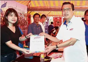  ??  ?? Job well
done: Liow presenting a certificat­e of appreciati­on to ‘Jom Gerak Teguh Bersama’ event officer Avelyn Seng in Bentong.