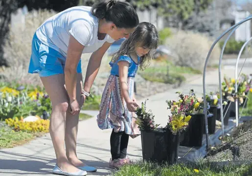  ??  ?? Above: Customers Kate Daigle, left, and her daughter, Natalie, 4, pick out a flower arrangemen­t on April 25 at Rowdy Poppy floral design and cultivatio­n on the sidewalk of the business at 31st and Gaylord streets in Denver.