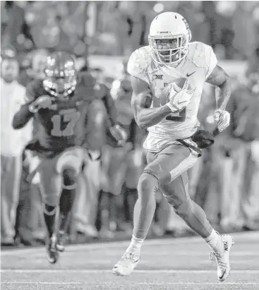  ?? Tom Pennington / Getty Images ?? Baylor is off and running to an impressive victory as KD Cannon gets behind the Oklahoma State defense on a 59-yard touchdown reception in the first quarter Saturday night. Cannon had five catches for 210 yards.