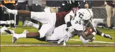  ?? Jessica Hill / Associated Press ?? UConn running back Kevin Mensah scores a touchdown as he is tackled by UMass linebacker Jarvis Miller on Saturday.