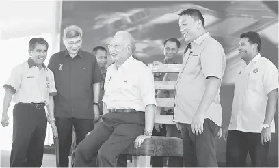  ?? — Gambar Bernama ?? BERKUALITI: Najib mencuba kerusi gergasi ketika merasmikan Muar Furniture Park dan Program Skim Usahawan Perabot Bumiputera semalam. Turut hadir Mah (dua kiri).