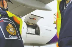  ?? CANADA Border SERVICES AGENCY FILES ?? Canada Border Services Agency officers watch as the first shipment of newly authorized Moderna COVID-19
vaccine is unloaded on Dec. 24.