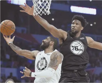  ?? AP PHOTO ?? UP AND UNDER: The Celtics’ Kyrie Irving goes up to the hoop against Philadelph­ia’s Joel Embiid during last night’s All-Star Game in Los Angeles.