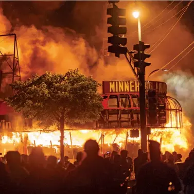  ??  ?? A CITY SEETHING When Minneapoli­s’s Third Police Precinct was set ablaze during protests over George Floyd’s killing, nearby buildings like this liquor store also went up in flames.