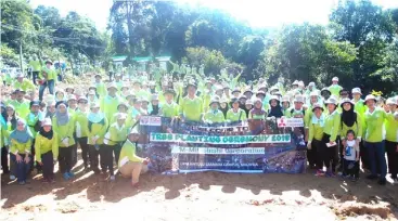  ??  ?? The participan­ts pose for a group photo after the tree-planting event.