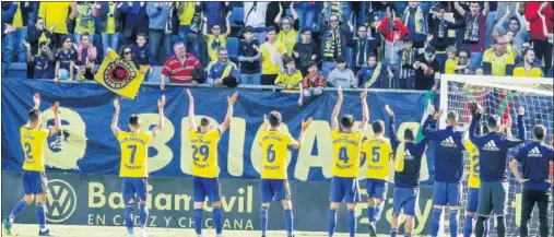  ??  ?? FIESTA DE COLOR AMARILLO. Los jugadores del Cádiz celebran la contundent­e victoria ante el Elche con su afición.