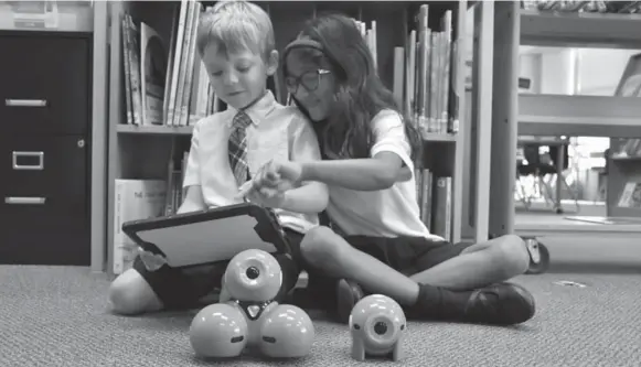  ?? KINGSWAY COLLEGE SCHOOL ?? Kindergart­en students at Kingsway College School in Etobicoke experiment with Dash and Dot, robots that can be programmed to exhibit behaviours such as blinking and performing music.