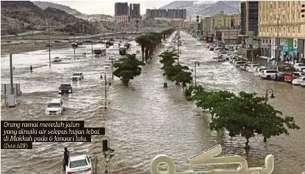  ?? (Foto AFP) ?? Orang ramai meredah jalan yang dinaiki air selepas hujan lebat di Makkah pada 6 Januari lalu.