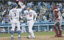  ?? Victor Decolongon Getty Images ?? JUSTIN TURNER (10), with Chris Taylor, was struggling after returning from an injury. His hitting came around after he borrowed a bat from Bellinger.