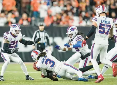  ?? JOSHUA A. BICKEL/AP ?? Bengals wide receiver Tee Higgins, on ground, collides with Buffalo Bills safety Damar Hamlin, front center, during the first half of their game Jan. 2 in Cincinnati. Hamlin was critically injured on the play.