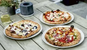  ?? Andy Colwell, Special to The Denver Post ?? Three wood-fired pizzas at Campfire in Evergreen: the potato pie with potato, bacon and chive cream, left; margherita, top; and grilled chicken pesto.
