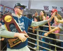  ?? AARON FLAUM/HARTFORD COURANT ?? Uconn freshman Donovan Clingan carries the national championsh­ip trophy as he celebrates with fans at Gampel Pavilion on Tuesday.
The Bristol Central grad was a key piece off the bench for the Huskies.