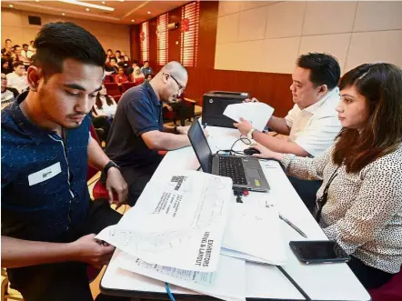  ??  ?? Representa­tives of the varous institutio­ns selecting the location of their booths at the fair’s balloting session in Menara Star.