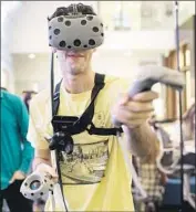  ?? Kent Nishimura Los Angeles Times ?? SAMUEL Maury-Holmes, 20, uses a virtual reality rig at a computer science show at Occidental College.