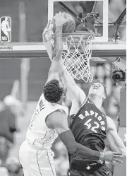  ?? Nick Wass / Associated Press ?? Wizards guard John Wall, left, goes strong to the basket against the Raptors’ Jakob Poeltl on Sunday.