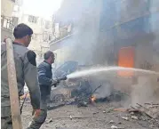  ?? [SYRIAN CIVIL DEFENSE WHITE HELMETS VIA THE ASSOCIATED PRESS] ?? Civil Defense workers put out a fire Tuesday following airstrikes and shelling in Douma, in the eastern Ghouta region near Damascus, Syria.
