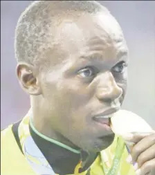  ??  ?? 2016 Rio Olympics Men’s 4 x 100m Relay Victory Ceremony - Gold medalist Usain Bolt (JAM) bites his medal. (REUTERS/Alessandro Bianchi)