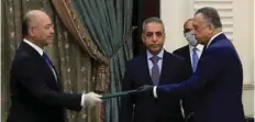  ??  ?? Iraqi President Barham Saleh, left, swearing in Mustafa Kadhemi as new prime minister-designate in Baghdad. —AFP