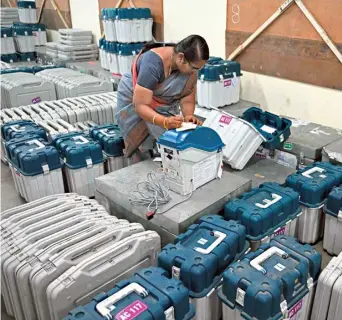  ?? AFP ?? Ensuring transparen­cy: An o™icial marks an EVM at a distributi­on centre in Coimbatore on April 11.