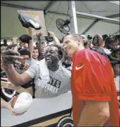  ?? Gerald Hubert The Associated Press ?? Saints quarterbac­k Drew Brees poses for photos with fans Friday at New Orleans’ training facility in Metairie, La.