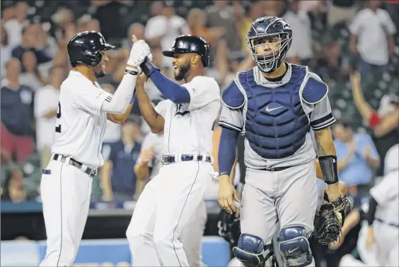  ?? Photos by Paul Sancya / Associated Press ?? Yankees catcher Gary Sanchez walks to the dugout as the Detroit Tigers celebrate a Jordy Mercer single to score Willi Castro in the ninth inning.