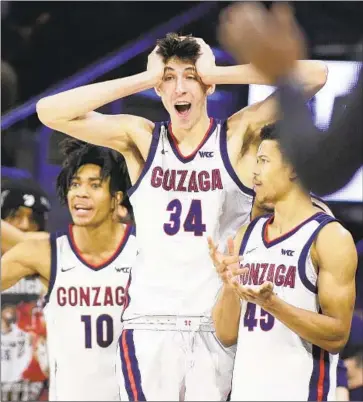  ?? Young Kwak Associated Press ?? HUNTER SALIS, Chet Holmgren and Rasir Bolton, right, react during a game against Pacific in February. Holmgren, an agile center with good ballhandli­ng skills, is projected to be selected second in the NBA draft.