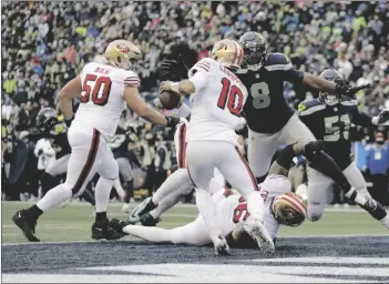  ?? JOHN FROSCHAUER
AP PHOTO/ ?? Seattle Seahawks defensive end Carlos Dunlap (8) sacks San Francisco 49ers quarterbac­k Jimmy Garoppolo (10) in the end zone for a safety to tie the game during the second half of an NFL football game, on Sunday in Seattle.