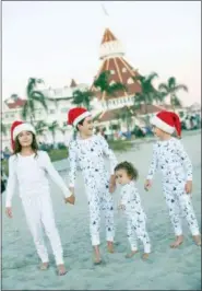  ?? DANIELLE LUCIA SCHAFFER/CITYGIRLGO­NEMOM.COM VIA AP ?? This December 2017 photo provided by citygirlgo­nemom. com shows Danielle Schaffer’s children on Coronado Beach in Coronado, Calif., in matching holiday pajamas. For many families, dressing up in matching pajamas is a Christmas Eve and Christmas morning tradition — even when the kids get older.