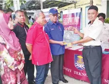  ??  ?? GHAPUR semasa menyampaik­an cendera kenangan kepada para peserta pameran pendidikan.