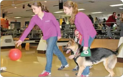  ??  ?? Jacquelyn Sherman rolls a bowling ball at Pike Lanes Jan. 13, as her sister, Danielle and Glory, watch. Glory was with the Sherman family as part of a training exercise for The Seeing Eye, Inc. (photo by Cary Beavers)