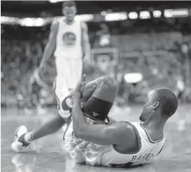  ?? CHRISTIAN PETERSEN/GETTY IMAGES ?? Harrison Barnes grabs his left leg after suffering a sprained ankle in the third period. The Warriors forward was helped off the court and did not return. X-rays were negative.